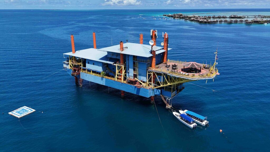 Sipadan Dive Rig, a converted oil platform in turquoise Bornean watersfloating above a stunning house reef.