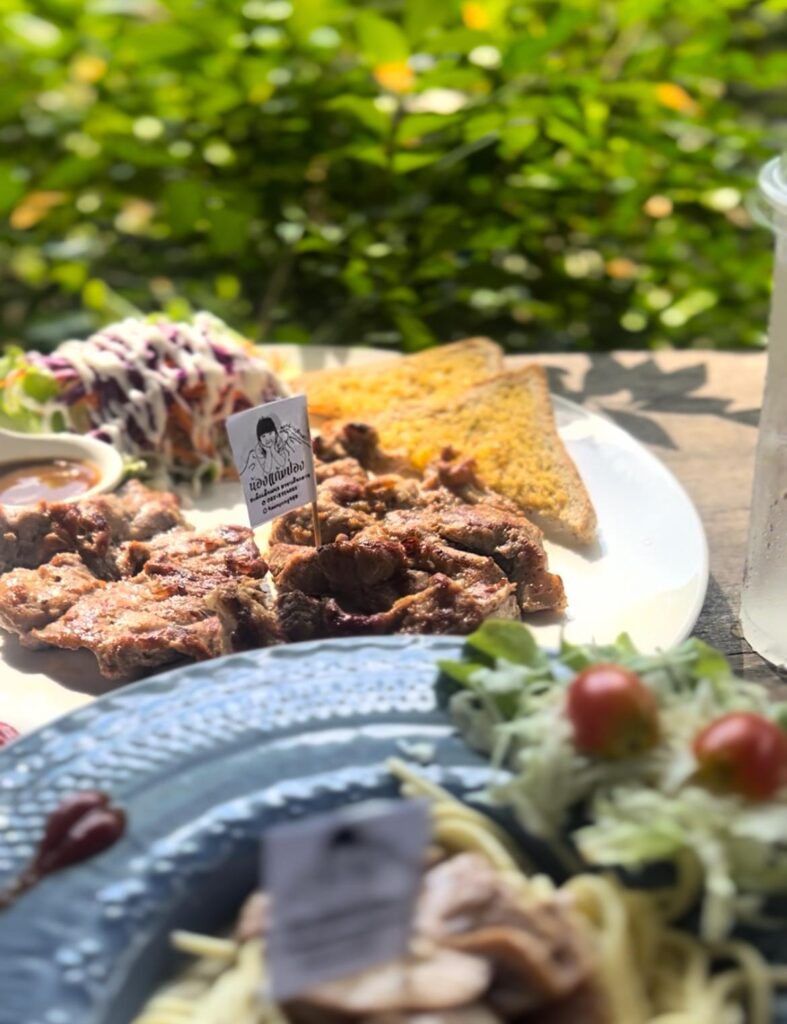 A perfectly grilled steak with crispy fries and salad, served on a wooden plate at สเต็กเด็กแนว Steak Dekneaw in Chiang Dao