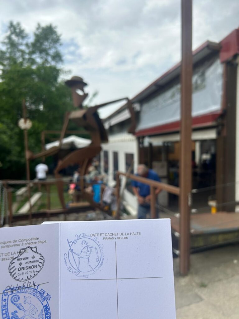 Cup of coffee and pilgrim passport with a Sello stamp from Parada de Zurain on the Camino de Santiago route.