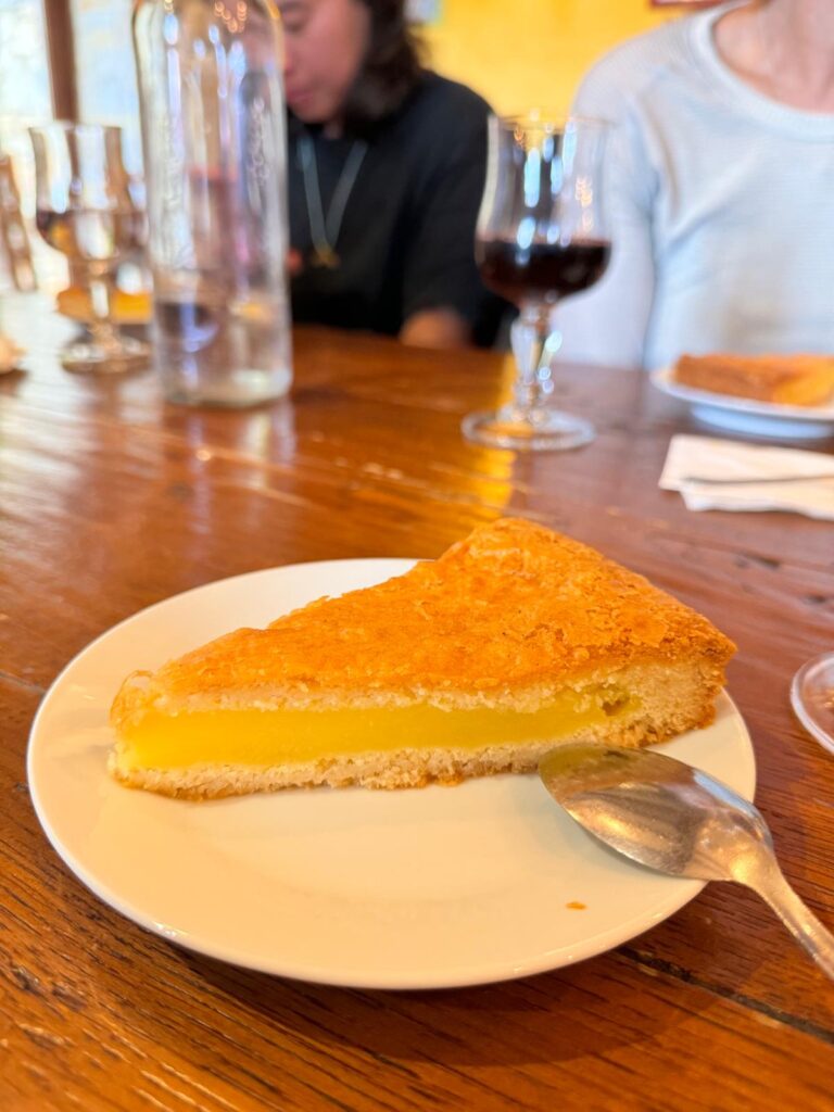 Traditional Spanish almond cake Tarta de Santiago topped with powdered sugar and a Cross of Saint James stencil on a rustic wooden table.